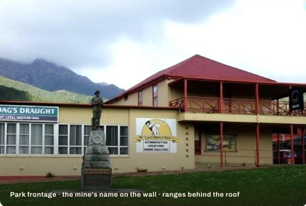 Mt Lyell Motor Inn with park frontage, war memorial and ranges behind the roof